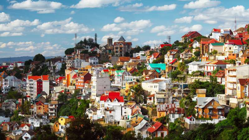 Elevated cityscape view of Antananarivo with red-roofed buildings and rice paddies